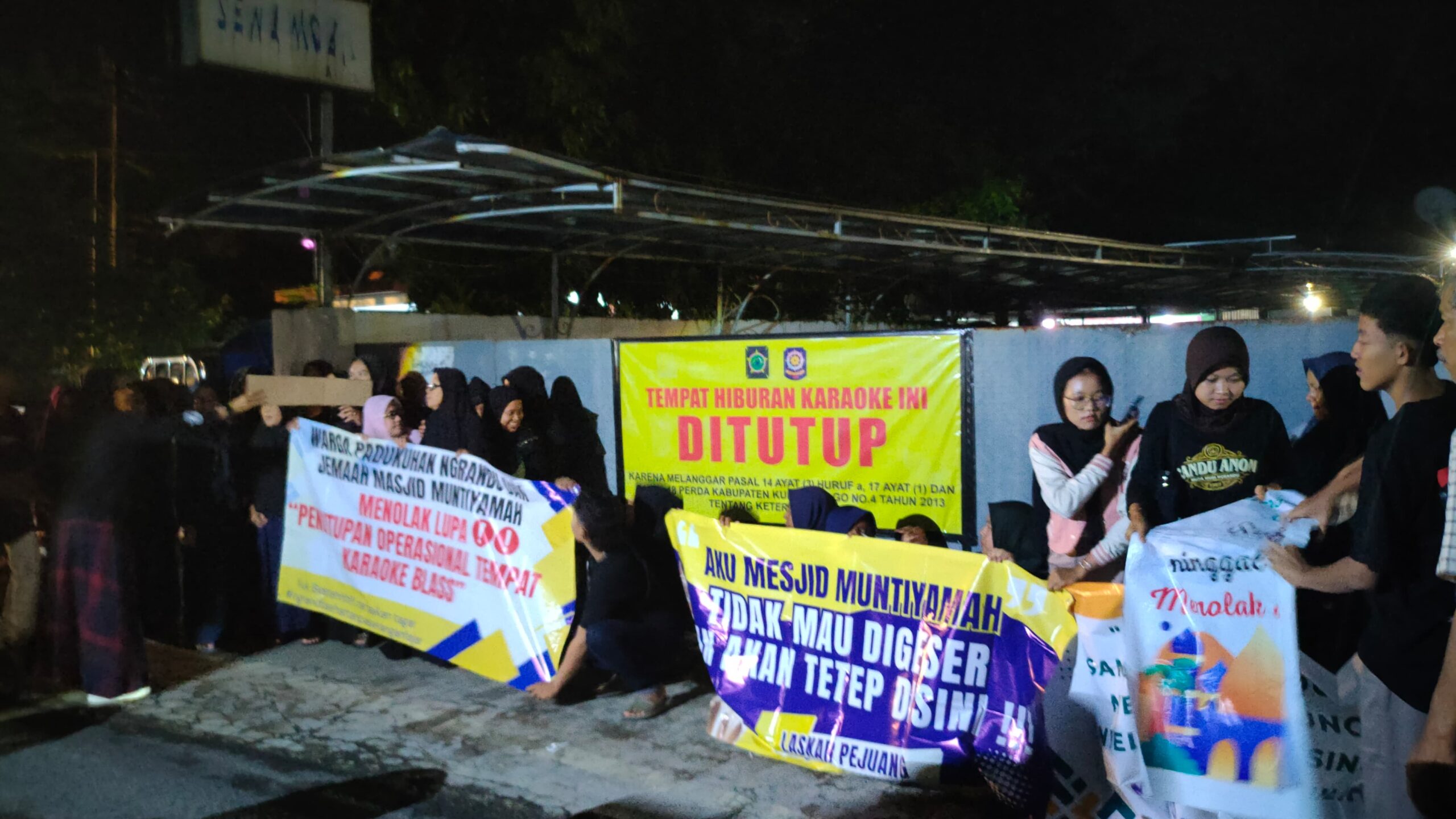 Warga menggelar aksi dengan membawa spanduk, menuntut penutupan tempat karaoke Blass Music. (Foto : Kuntari / newsway.co.id)